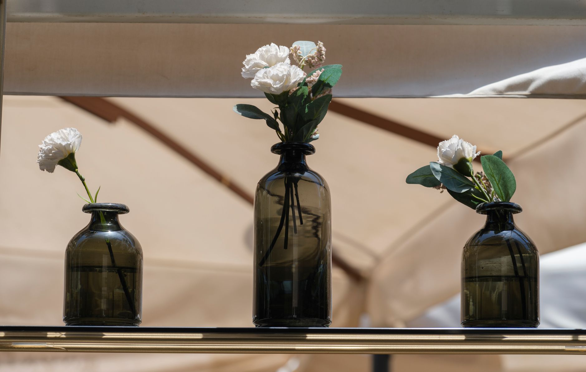 Three glass vases with white flower arrangements