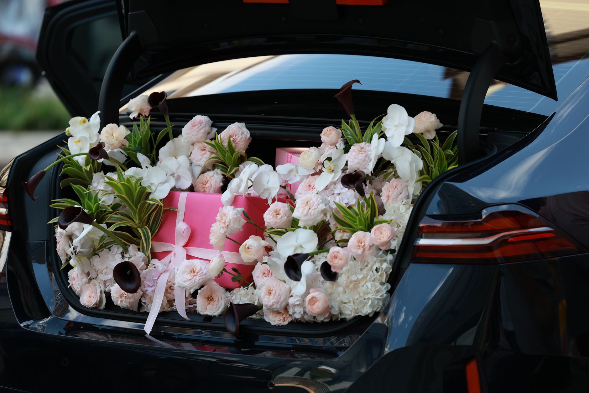 Floral arrangement ready for local delivery in a car trunk
