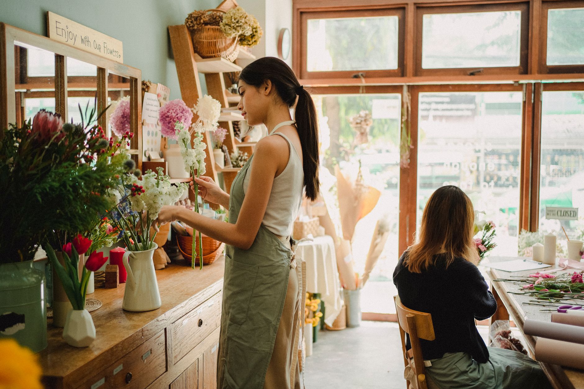 Florists making bouquets of fresh flowers together in a floristry studio
