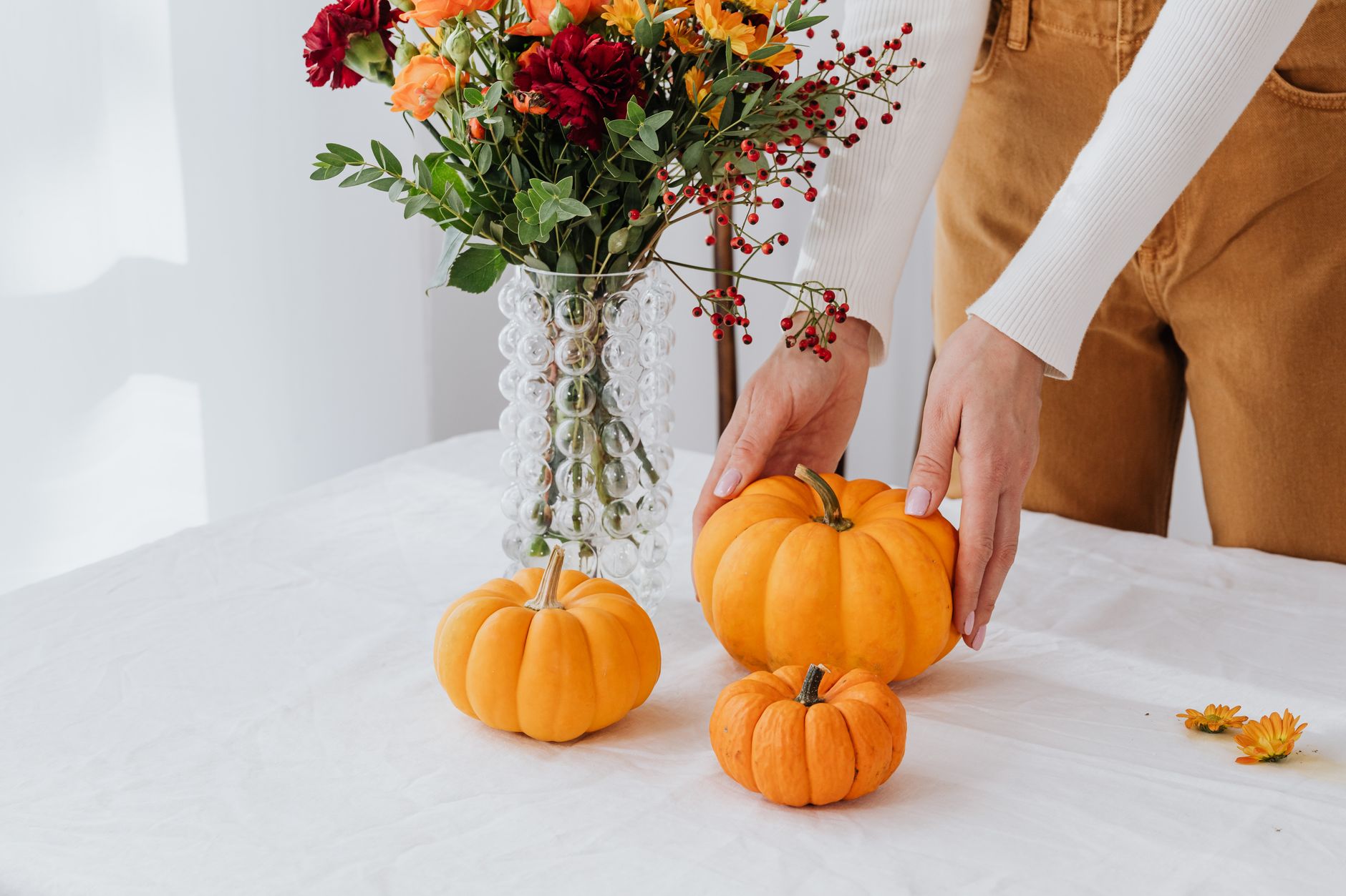 Pumpkins and a fall flower arrangement displayed on a table